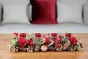 An advent wreath with four red candles on a wooden table. Voir les images du produit