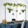 A table set for a meal, decorated with a hanging arch of greenery and lights. Náhled obrázku produktu