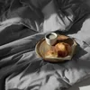 A breakfast setting on a bed with a croissant and coffee. Produktbild-Vorschau