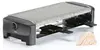 A raclette grill with a stone top and eight small pans underneath, along with a stack of wooden spatulas. Produktbild-Vorschau