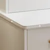 A close-up view of the rounded corner of a white vanity table with a drawer below. Náhľad obrázku produktu