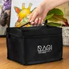 A hand holding a black marker bag with artwork in the background. Náhľad obrázku produktu