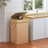 A bamboo trash can with a lid is placed next to a kitchen sink. Voir les images du produit
