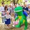 A family is gathered outdoors for a party, with a person in an inflatable dinosaur costume. Náhled obrázku produktu