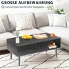 A black coffee table with items on it, placed in a living room setting with a sofa in the background. Voir les images du produit