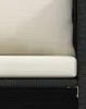A close-up view of a section of a black rattan sofa with beige cushions. Náhľad obrázku produktu