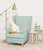 A plush goose toy sits on a light blue armchair next to two small side tables. A floor lamp is to the left of the chair. Anteprima dell’immagine prodotto
