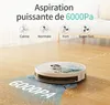 A robot vacuum cleaner is shown on a wooden floor, cleaning up rice grains. The image highlights the vacuum's suction power. Náhled obrázku produktu