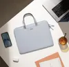 A laptop bag, laptop, phone, and earbuds are arranged on a white surface with shadows. Náhľad obrázku produktu