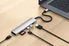A Satechi USB-C hub is connected to a laptop, with various cables and an SD card plugged into the hub. Náhled obrázku produktu