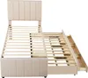 A beige upholstered bed frame with a headboard and a pull-out trundle bed with drawers, shown from a slightly elevated side angle against a white background. Produktbild-Vorschau