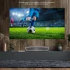 A living room setup with a large TV displaying a soccer game, a soundbar, and decorative items on a cabinet. Produktbild-Vorschau