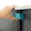 A hand is shown attaching a teal-colored accessory to a gray surface, possibly a table or desk. Produktbild-Vorschau