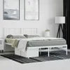 A white metal bed frame with a headboard, dressed with bedding, is shown in a bedroom setting. Náhled obrázku produktu