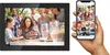 A digital photo frame displaying a family birthday celebration, with a hand holding a smartphone showing the same image and app interface. Produktbild-Vorschau