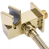A close-up, studio shot of a gold-colored shower head holder with a flexible hose attached. Náhled obrázku produktu