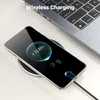 A smartphone is wirelessly charging on a charging pad next to a laptop. Produktbild-Vorschau
