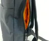 A close-up view of the side of a black backpack, showing an open zipper revealing an orange interior. Produktbild-Vorschau