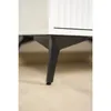 A close-up view of the black metal legs of a piece of furniture, likely a cabinet or dresser, resting on a light-colored wooden floor. Produktbild-Vorschau