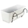 A white balcony planter with a rattan-like texture and black metal hooks for hanging. Produktbild-Vorschau