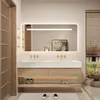A modern bathroom with a double sink vanity, illuminated mirror, and a window with a view of greenery. Anteprima dell’immagine prodotto