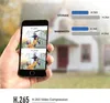 A hand holding a smartphone displaying two video clips, one labeled H.265 and the other H.264, with a house in the background. A comparison chart for storage and bandwidth is also visible. Produktbild-Vorschau