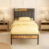 A single bed with yellow bedding is shown in a bedroom setting with nightstands and lamps on either side. Náhľad obrázku produktu