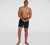 A man wearing navy blue Speedo swim trunks stands against a white background. Produktbild-Vorschau