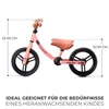 A pink balance bike with dimensions indicated by measurement lines and text. Náhled obrázku produktu