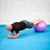 A man is doing a plank exercise with his feet on a gym ball. Voir les images du produit