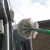 A cleaning brush on an extension pole is being used to clean cobwebs from the side of a building. Produktbild-Vorschau