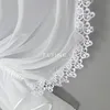 A close-up of a white sheer curtain with lace trim. Produktbild-Vorschau