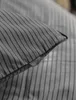 A close-up of a pillow with a striped pattern and a brand tag. Produktbild-Vorschau