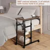A rolling side table with a laptop and a cup of coffee next to a bed. Produktbild-Vorschau