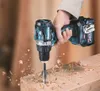 A hand holding a cordless drill, drilling into a piece of wood, with wood shavings flying. Produktbild-Vorschau