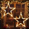 Christmas-themed window decoration with star lights, a decorated Christmas tree visible through the window, and a table set for a meal. Náhled obrázku produktu