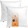 Two white pillows are shown, one slightly behind the other, with a product tag attached to the front pillow. Produktbild-Vorschau