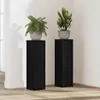 Two black plant stands with plants on top, placed in a room. Produktbild-Vorschau