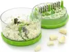 A garlic chopper with its components and some garlic cloves. Produktbild-Vorschau