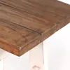 A close-up view of the edge of a wooden bench with a white base. Anteprima dell’immagine prodotto