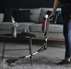 A person is using a vacuum cleaner in a modern living room with a sofa and coffee table. Produktbild-Vorschau