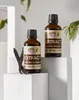 Two bottles of vanilla extract are displayed on white pedestals, with vanilla beans in the foreground. Náhled obrázku produktu