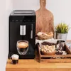 A coffee machine on a kitchen counter with coffee beans, sugar cubes, and cookies. Produktbild-Vorschau