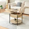 A round coffee table with a lift-top and storage compartment, placed in a living room setting next to a sofa. Podgląd zdjęcia produktu