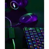 A gaming mouse, keyboard, and headphones are arranged on a dark surface with colorful lighting. Produktbild-Vorschau