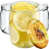 Three glass jars, one filled with lemon slices and liquid, and a lid with a bee on a sunflower. Voir les images du produit