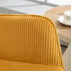 A close-up view of a yellow corduroy armchair with a wooden table and a cup of coffee in the background. Náhled obrázku produktu