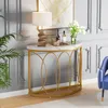 A console table with a marble top and gold metal frame, decorated with a lamp, bottles, and flowers. A blue chair is partially visible on the right. Podgląd zdjęcia produktu