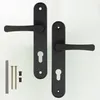Two black door handles with keyhole plates and some screws and caps are laid out on a white background. Náhled obrázku produktu
