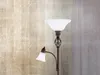 A close-up of a floor lamp with two lights against a textured wall. Produktbild-Vorschau